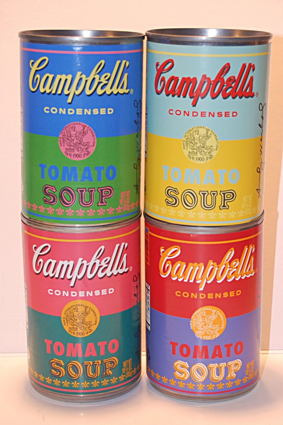 Stack of Andy Warhol Campbell's Soup Cans, featuring Tomato Soup in various color combinations.