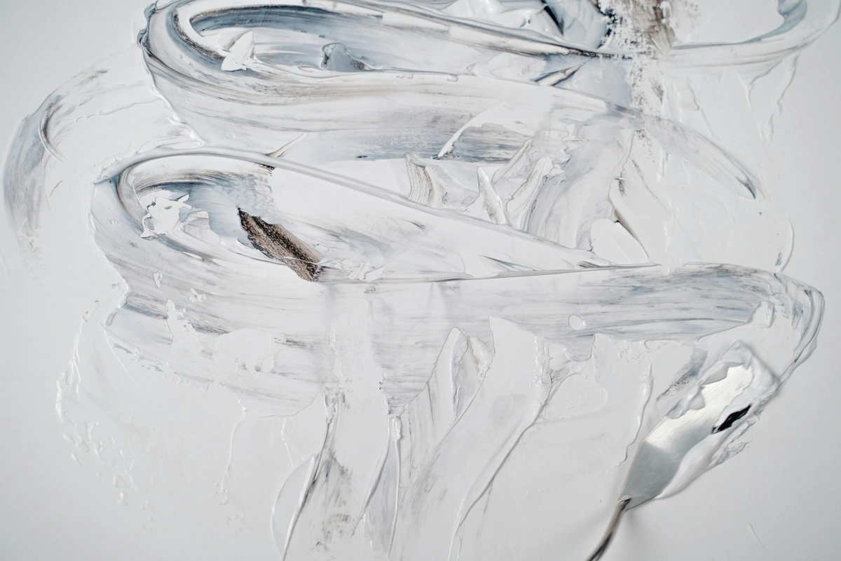 Abstract texture created with a palette knife and white and grey paint, showcasing thick impasto strokes and subtle color variations. / Textura abstracta creada con una espátula y pintura blanca y gris, mostrando pinceladas gruesas de impasto y sutiles variaciones de color.