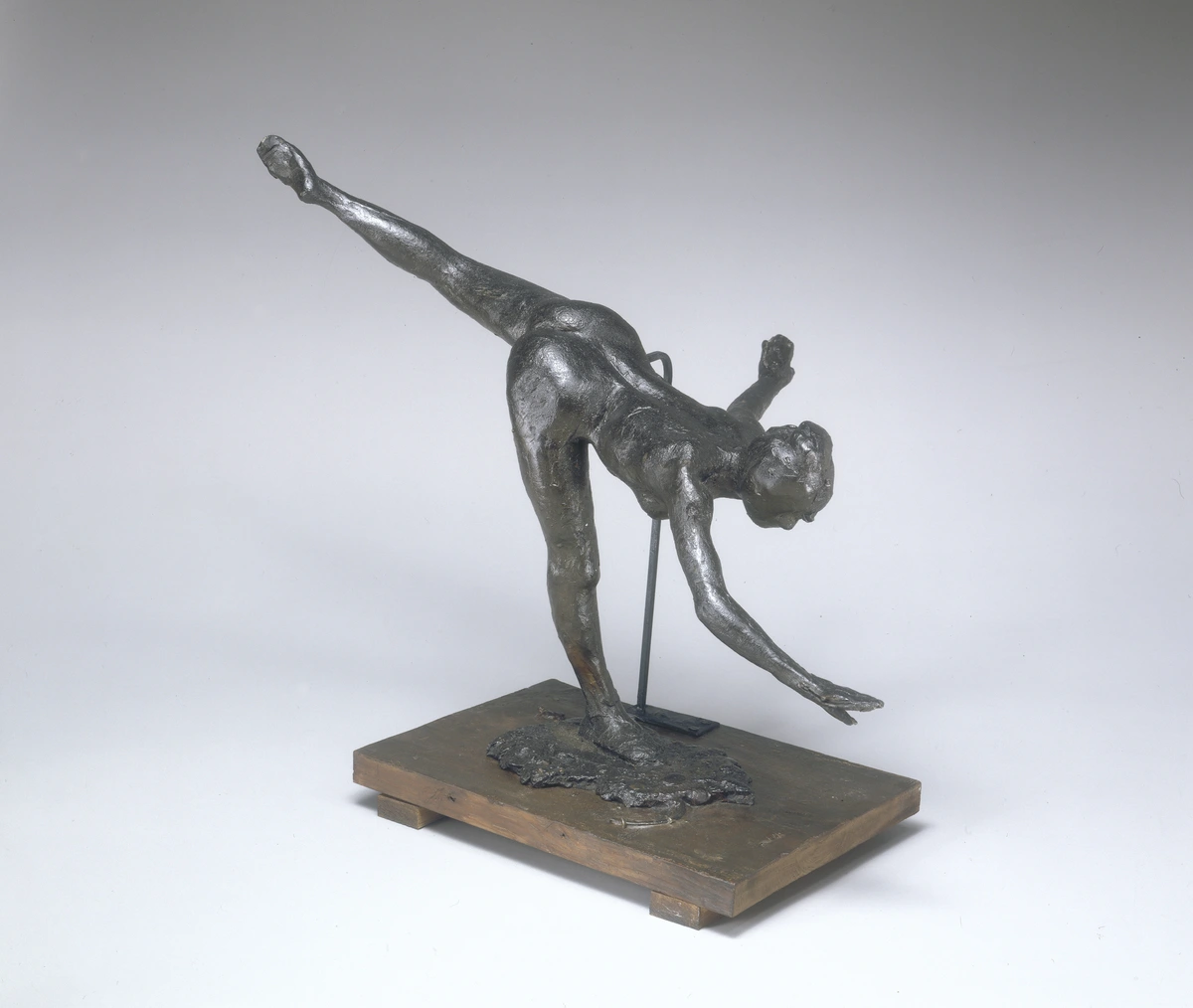 Bronze sculpture of Edgar Degas' 'Grande Arabesque, Third Time (First Arabesque)', depicting a dancer in a dynamic pose, balanced on a wooden base.