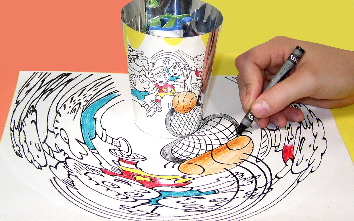 Child coloring an anamorphic art drawing of a basketball game around a cup