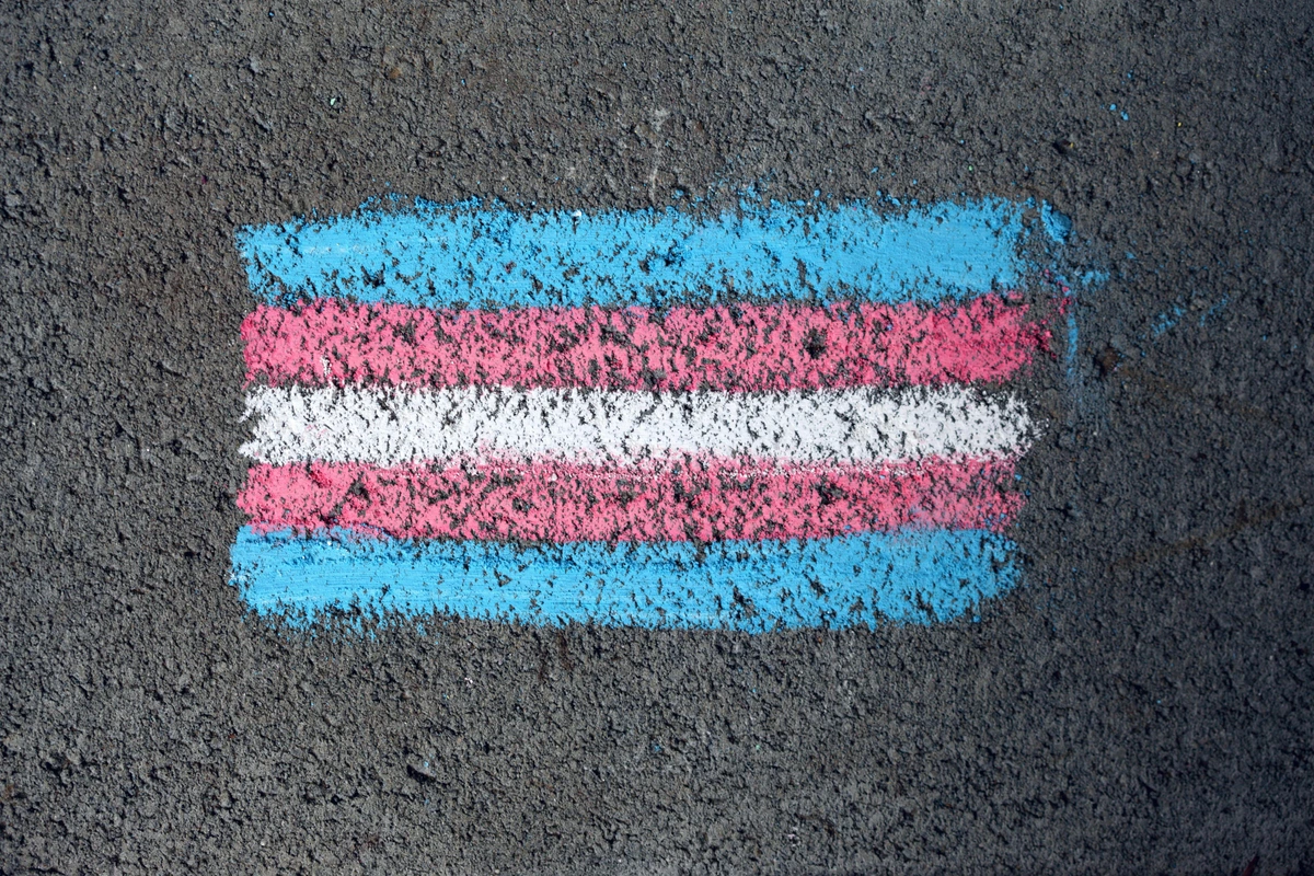 Hand-drawn pride flag in blue, red and white stripes on asphalt surface