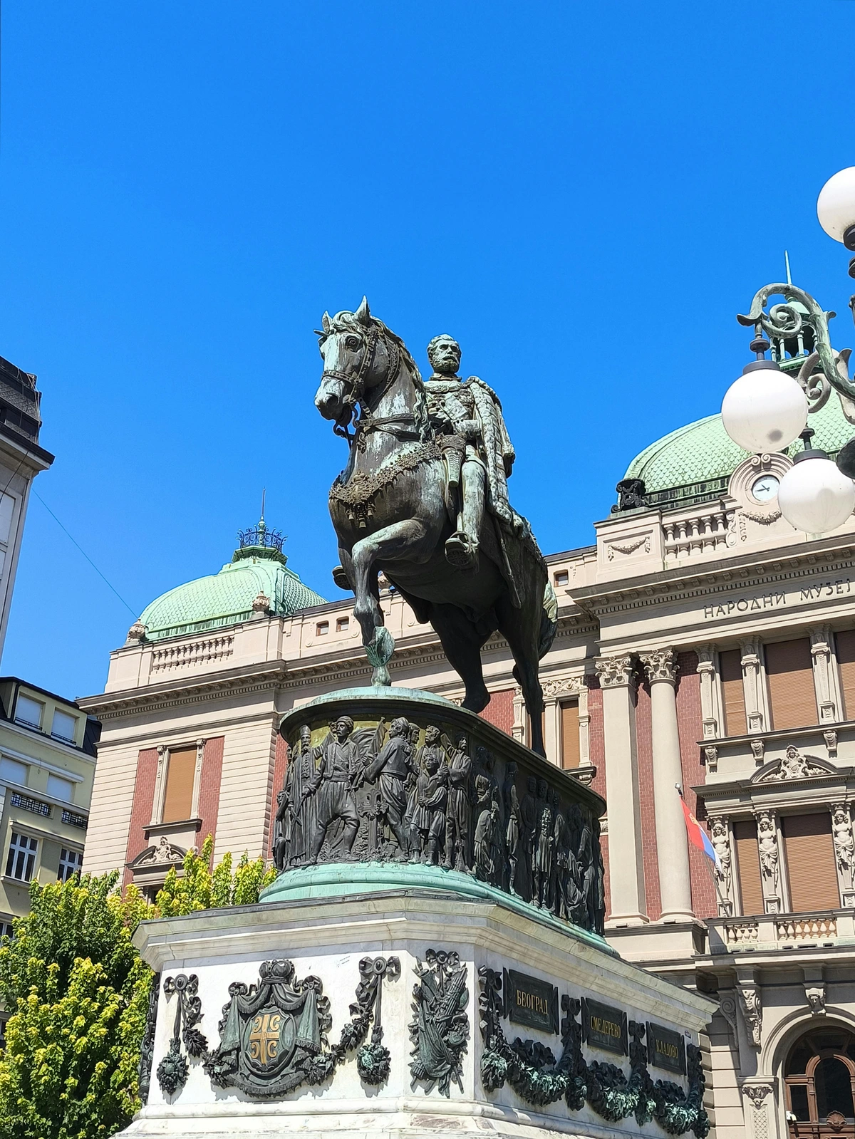Equestrian statue of a historical figure surrounded by civic symbols and intricate carvings.