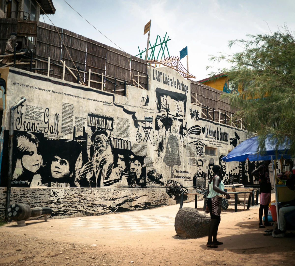 Civic pride mural showcasing Senegal artists and cultural heritage on town wall