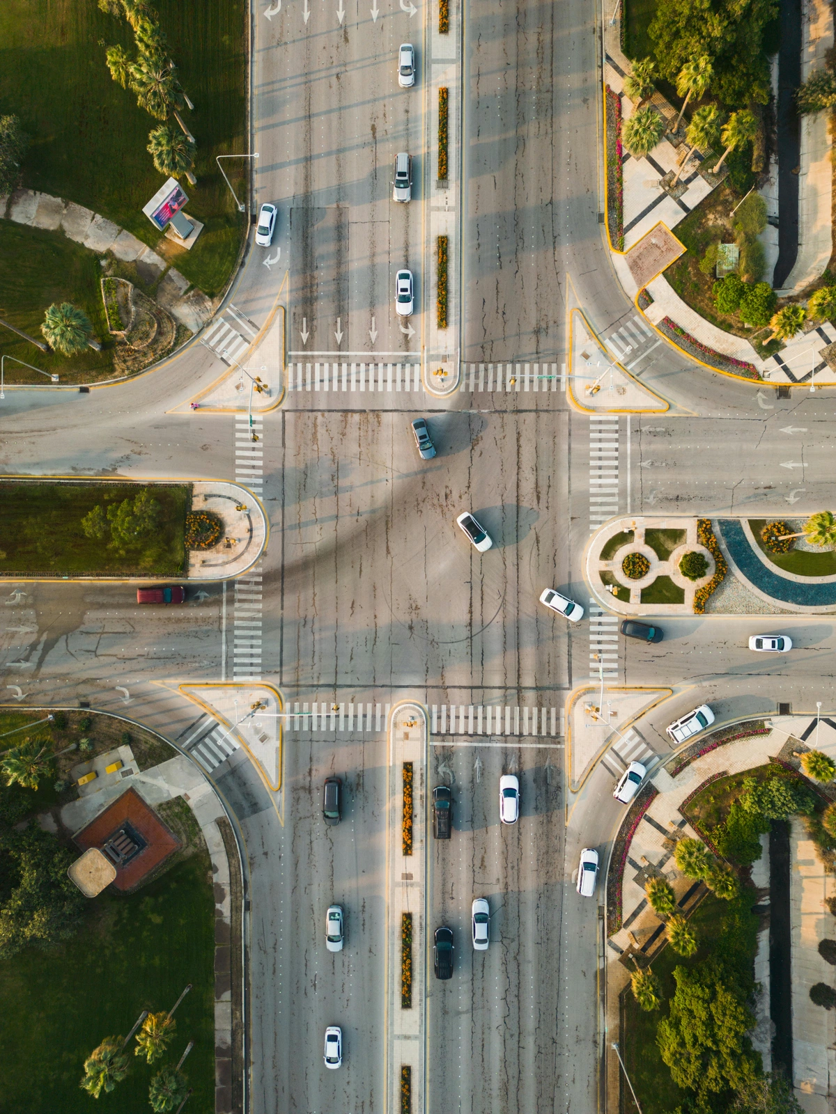Vehicles orderly positioned at a pristine street intersection, highlighting meticulous traffic planning and uniform spacing within the urban design framework.