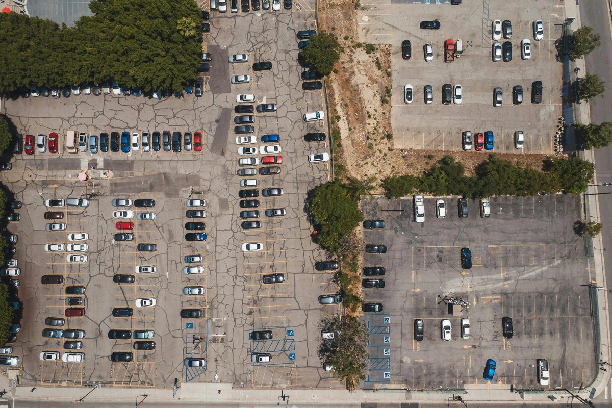 Aerial view of neatly parked cars in an organized parking lot showcasing consistent spacing.