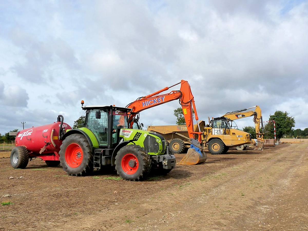 Modern farming tractors on plowed fertile ground