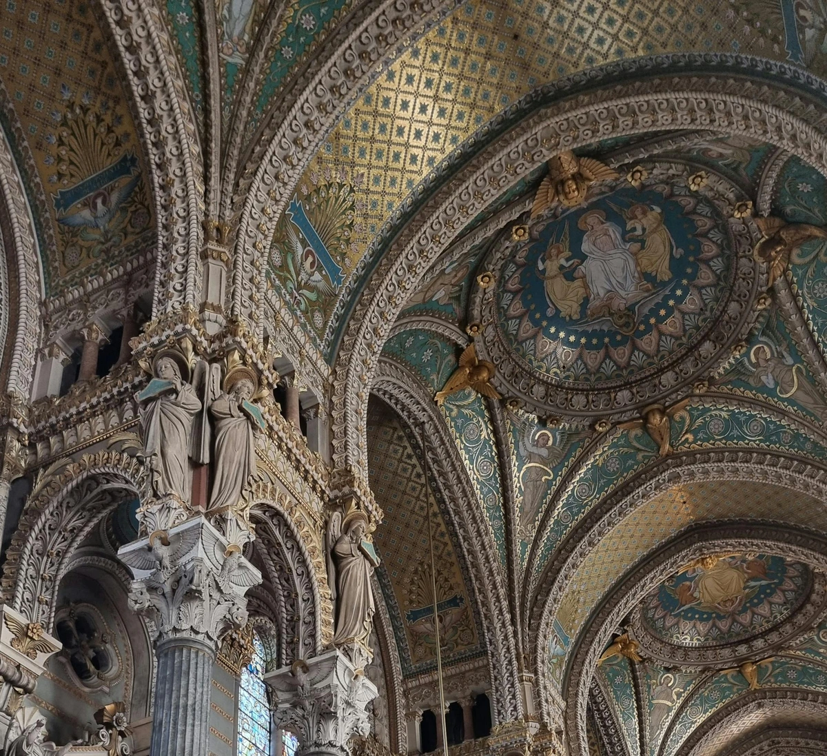 Paintings and sculptures on church ceiling showcasing the gold standard in art.