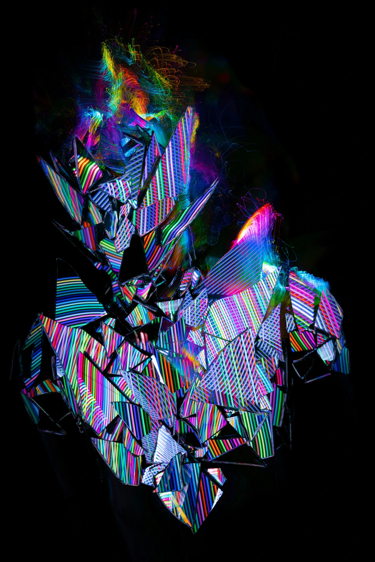Abstract light painting of a distorted, human-shaped form made of shattered crystal shards illuminated with vibrant rainbow-colored neon lights.
