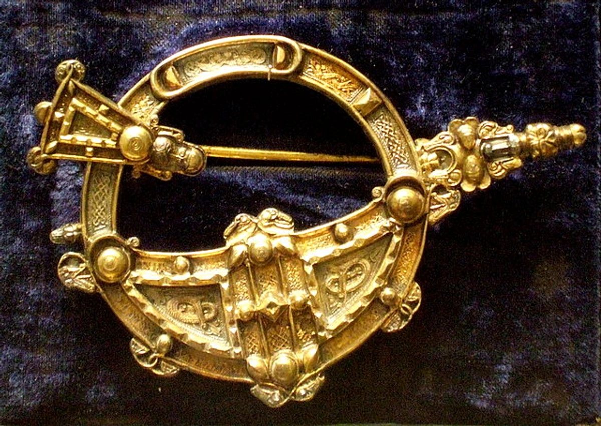 Iron Age Tara brooch artwork with Celtic design from British Museum, Ireland 8th century artifact, DP fabric arm ornament on fur coat, metalwork brooch with elaborate Celtic knot patterns, historical English brooch jewelry, muuman museum display arm applications brooch accessorizing