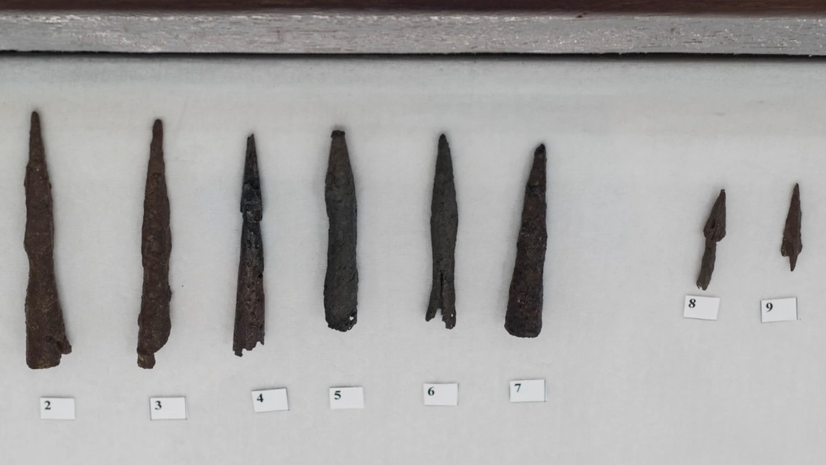Roman iron spear points, ballista bolts, and arrowheads, Iron Age artifacts displayed in a museum exhibit.