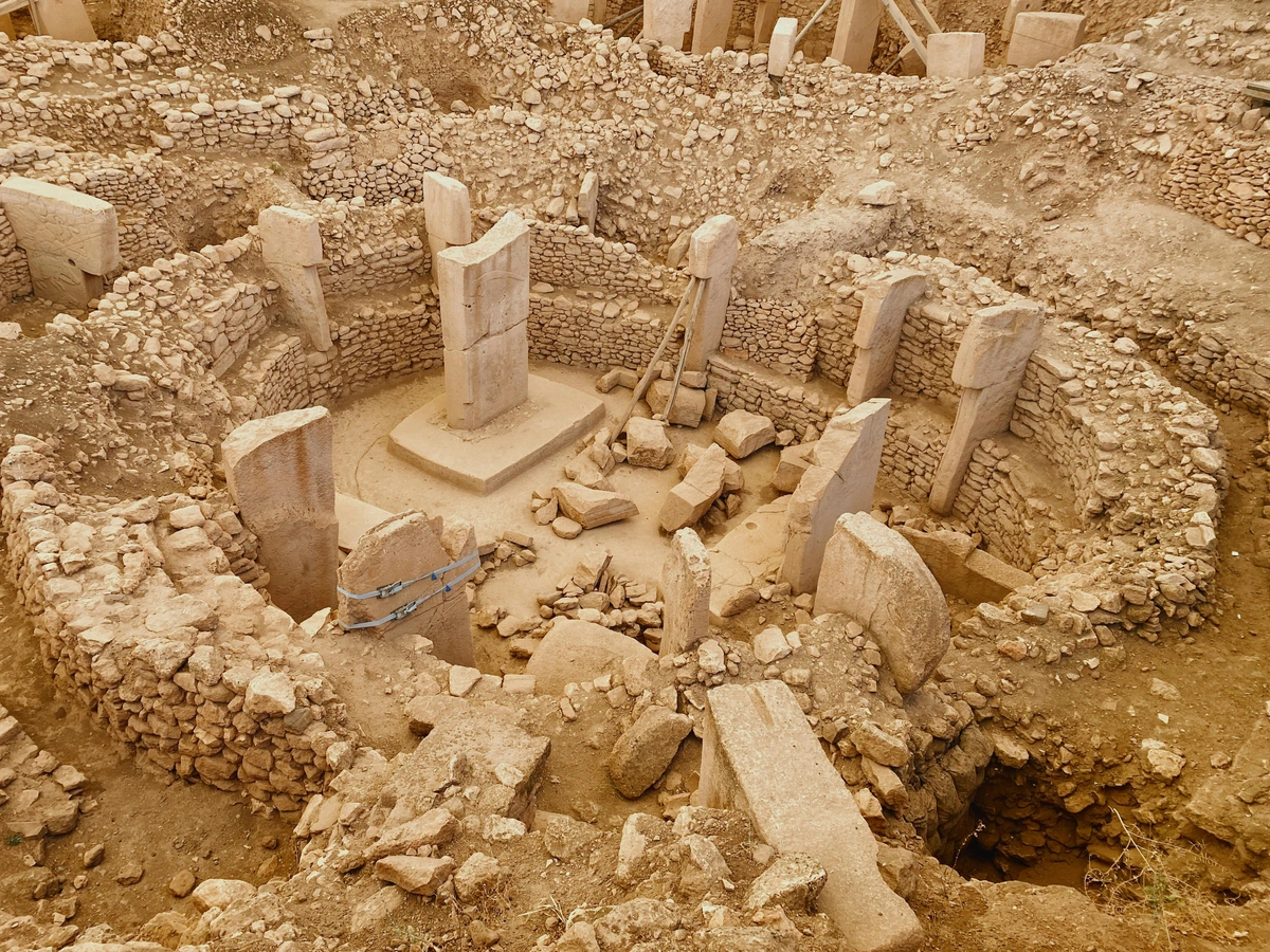 View of Göbekli Tepe, an ancient archaeological site with T-shaped megalithic pillars and stone walls.