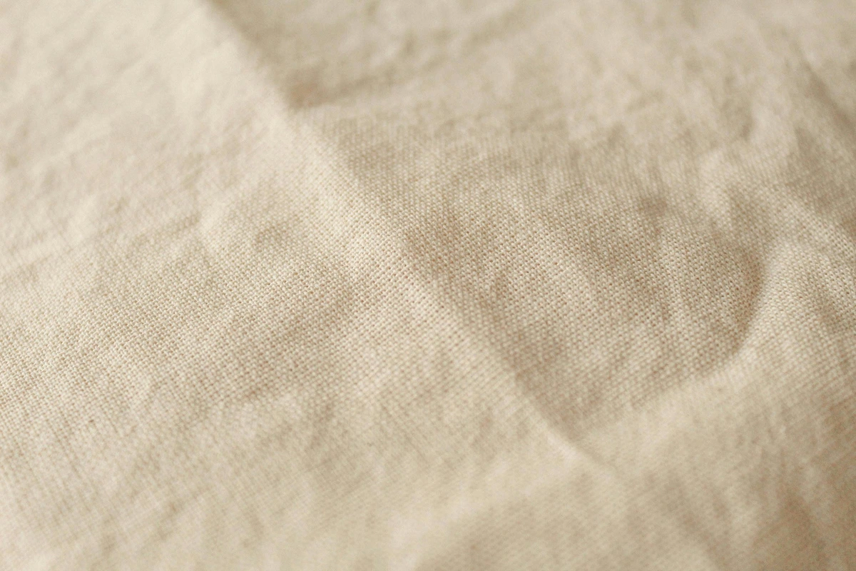 Close-up of a textured, off-white canvas fabric, ideal for painting backgrounds.
