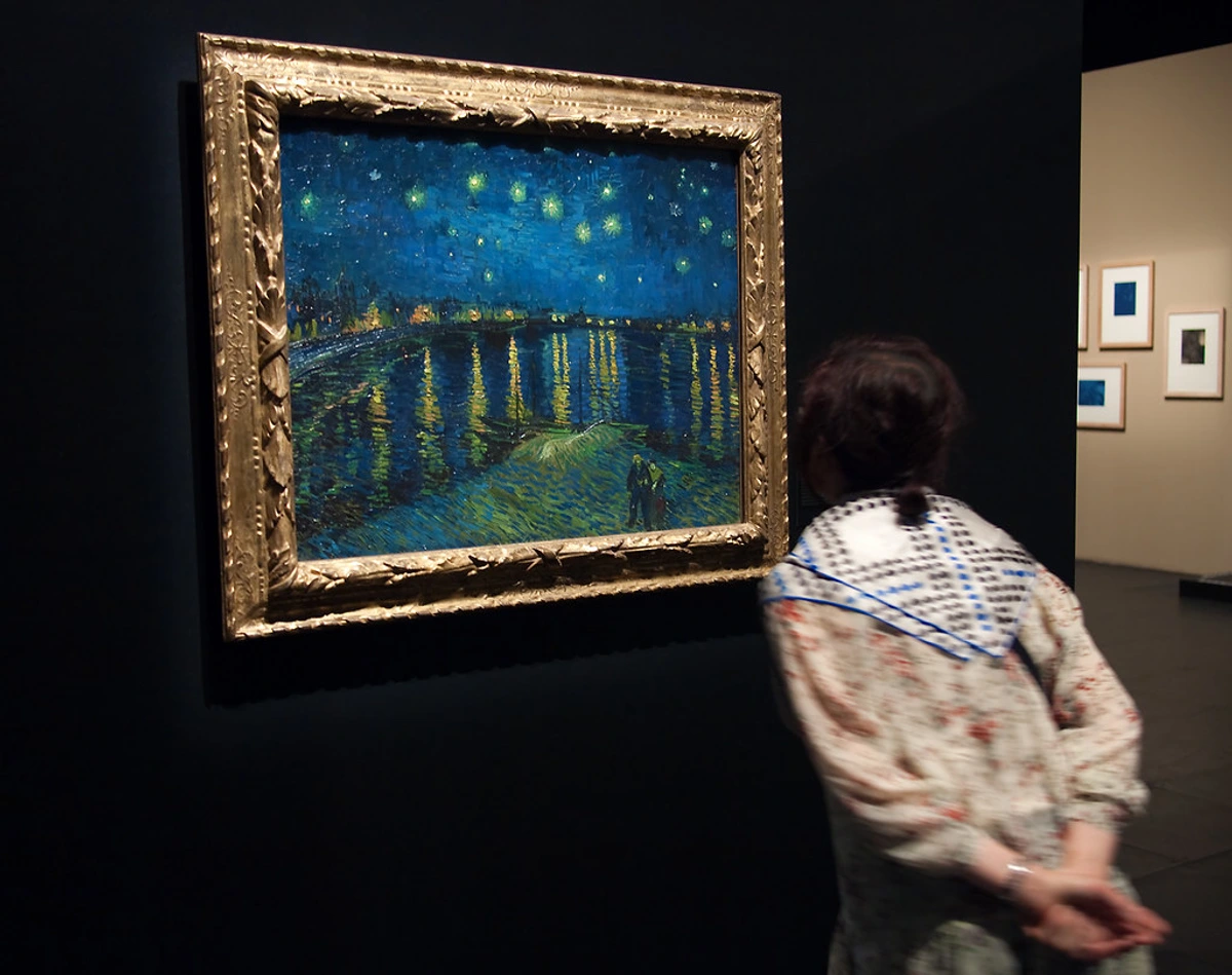 Vincent van Gogh's Starry Night Over the Rhône at the Musée d'Orsay, capturing swirling stars and a gaslit bridge