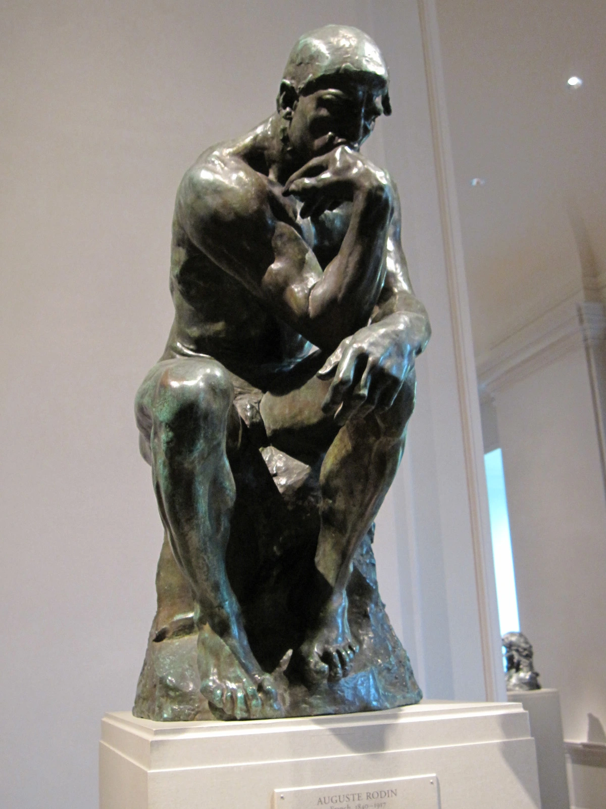 The Thinker sculpture by Auguste Rodin, a bronze statue of a man in deep contemplation, displayed at the National Gallery of Art.
