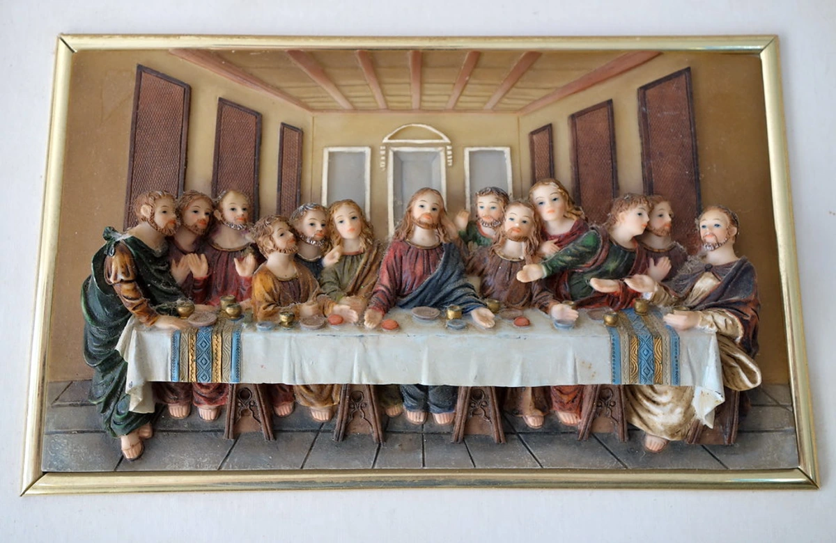 Bas-relief wall art depicting The Last Supper with Jesus and the twelve Apostles gathered around a table.