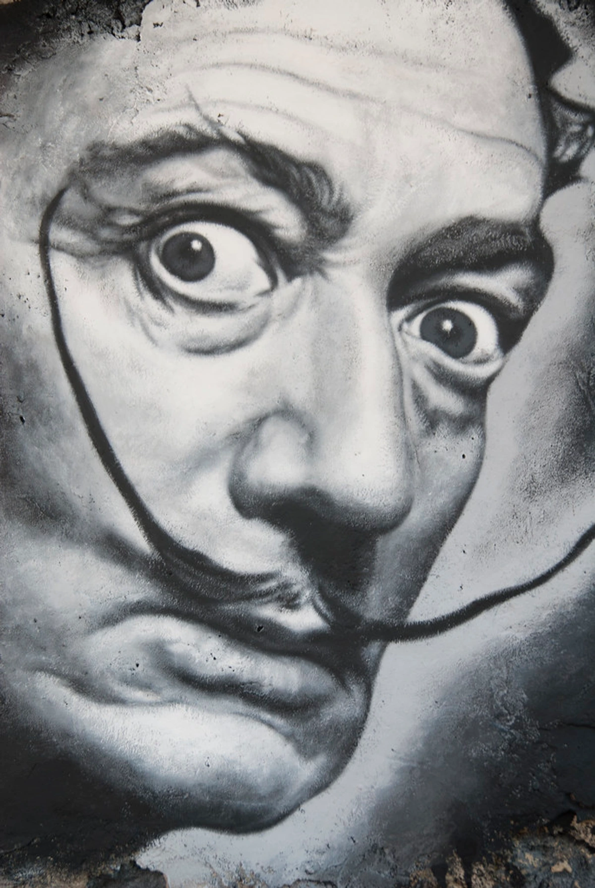 Graffiti portrait of the surrealist artist Salvador Dalí with his signature mustache and intense gaze.