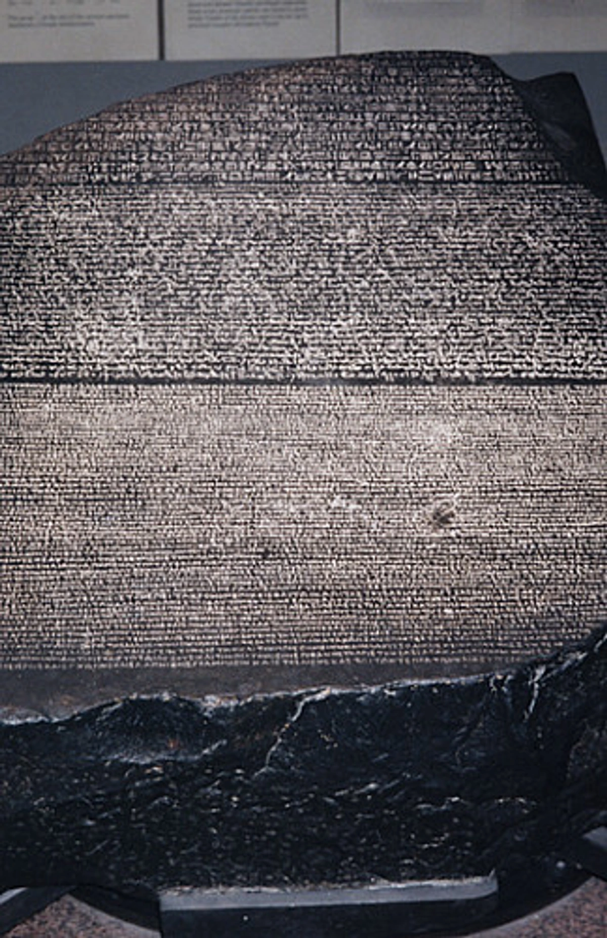 The Rosetta Stone, displaying three distinct scripts: hieroglyphic, demotic, and ancient Greek, crucial for deciphering Egyptian hieroglyphs.