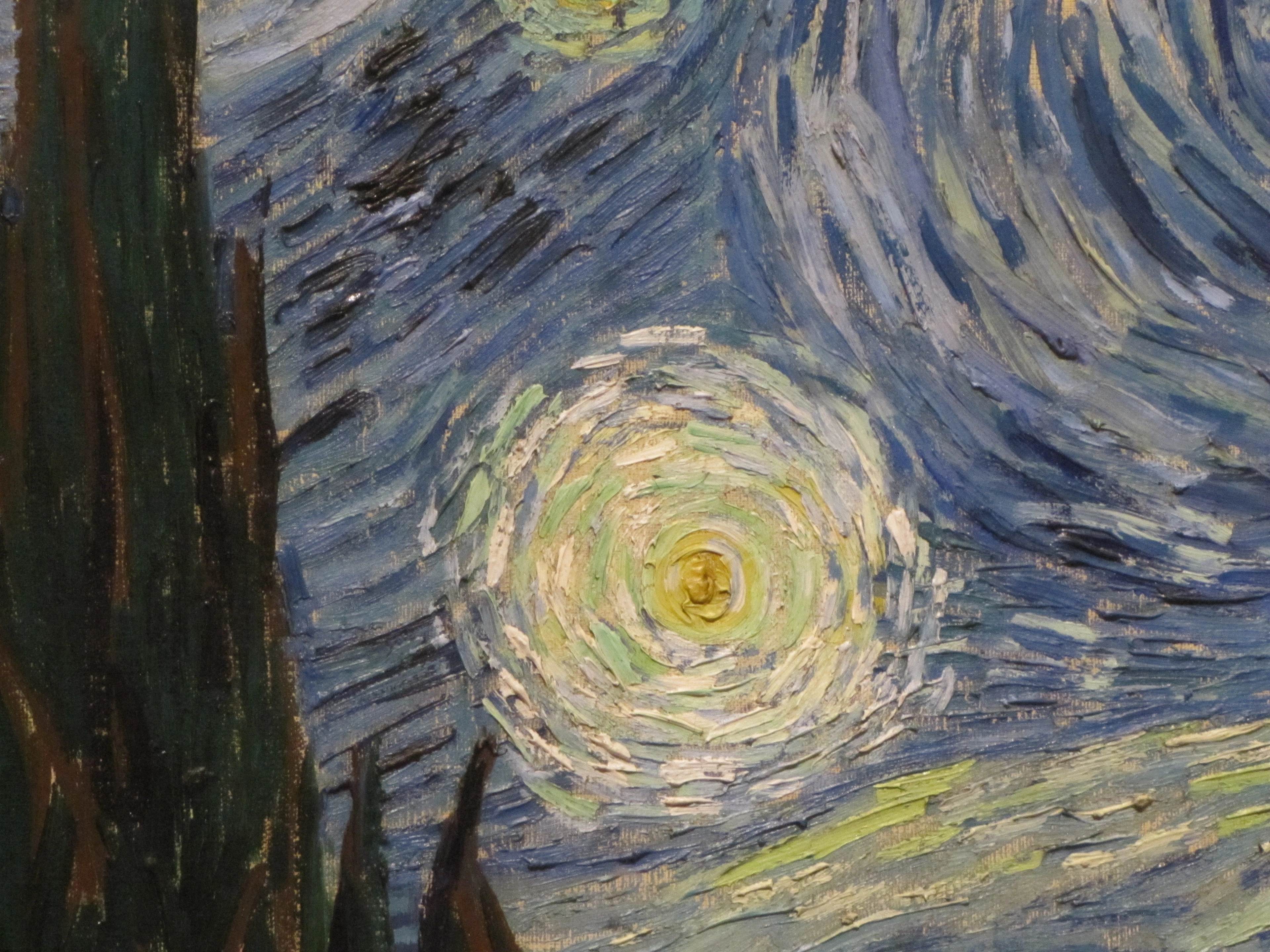 Close-up of Van Gogh's Starry Night showing swirling sky and cypress tree detail