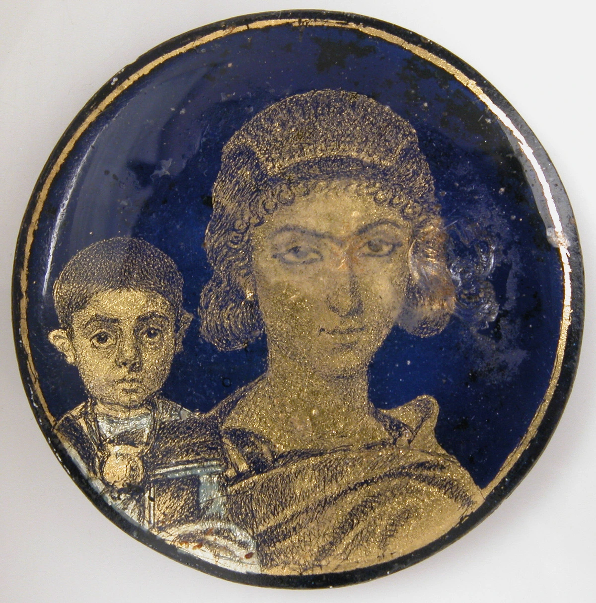 Gold glass medallion depicting a mother and child, likely from the Roman or Byzantine era.