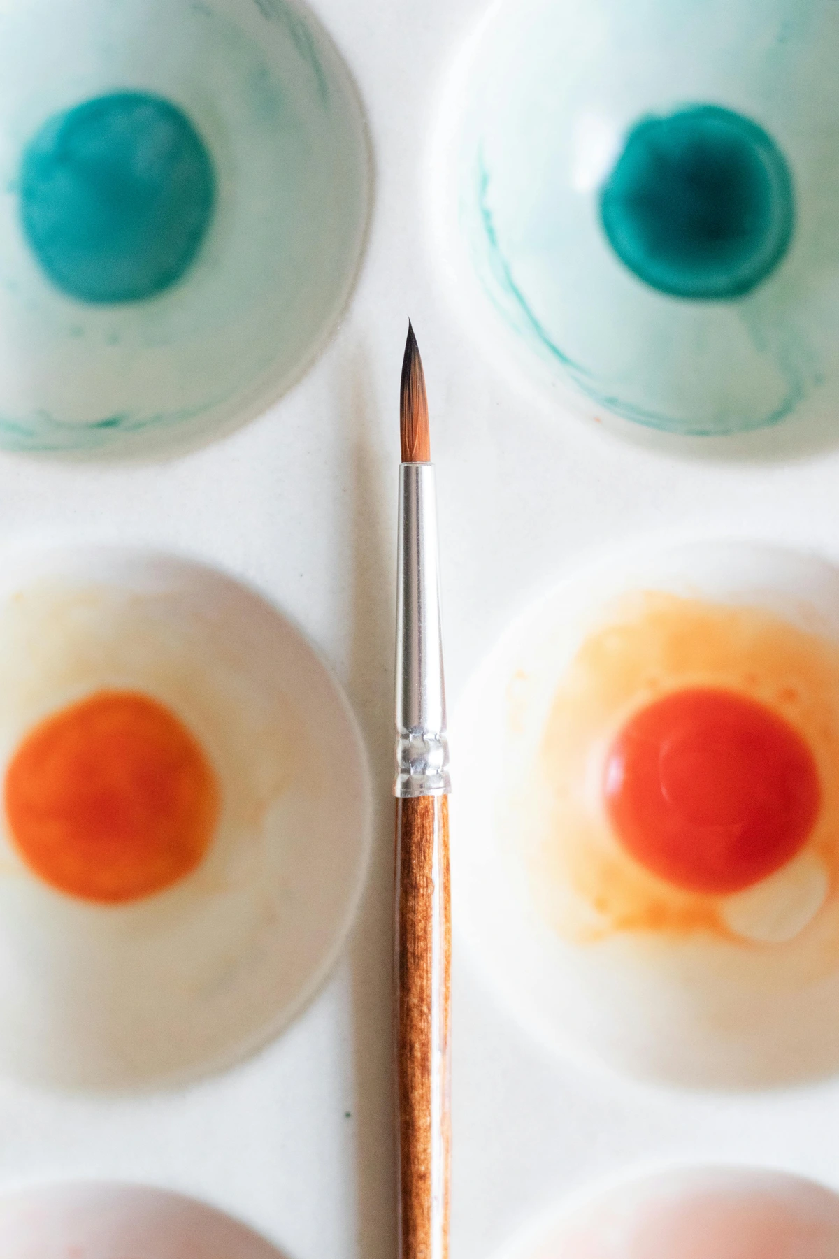 A palette with colorful watercolor paints and a brush, illustrating the basic tools for color mixing.