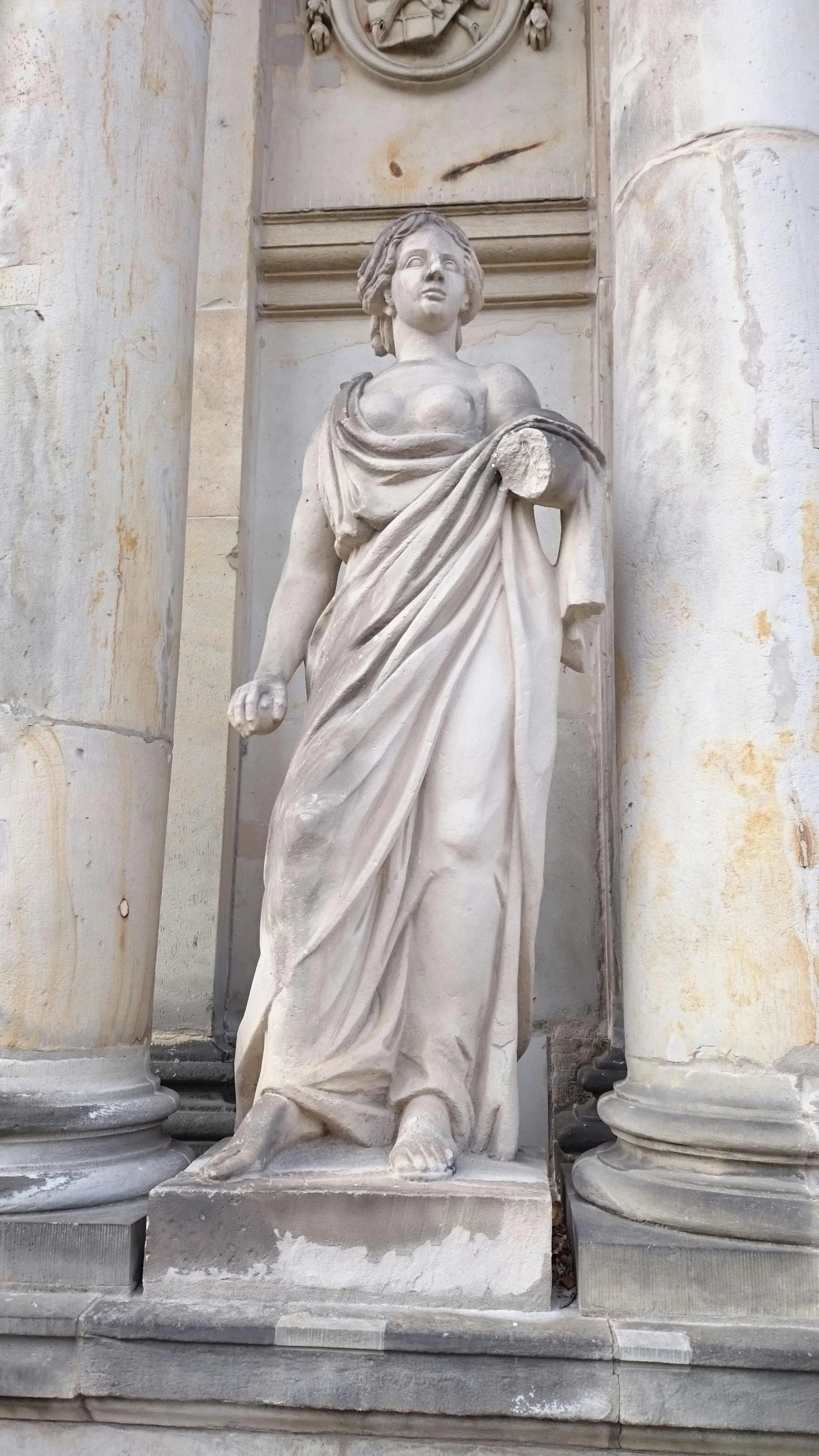 A white marble statue of a graceful woman in a draped classical gown, showcasing timeless artistic detail and craftsmanship.