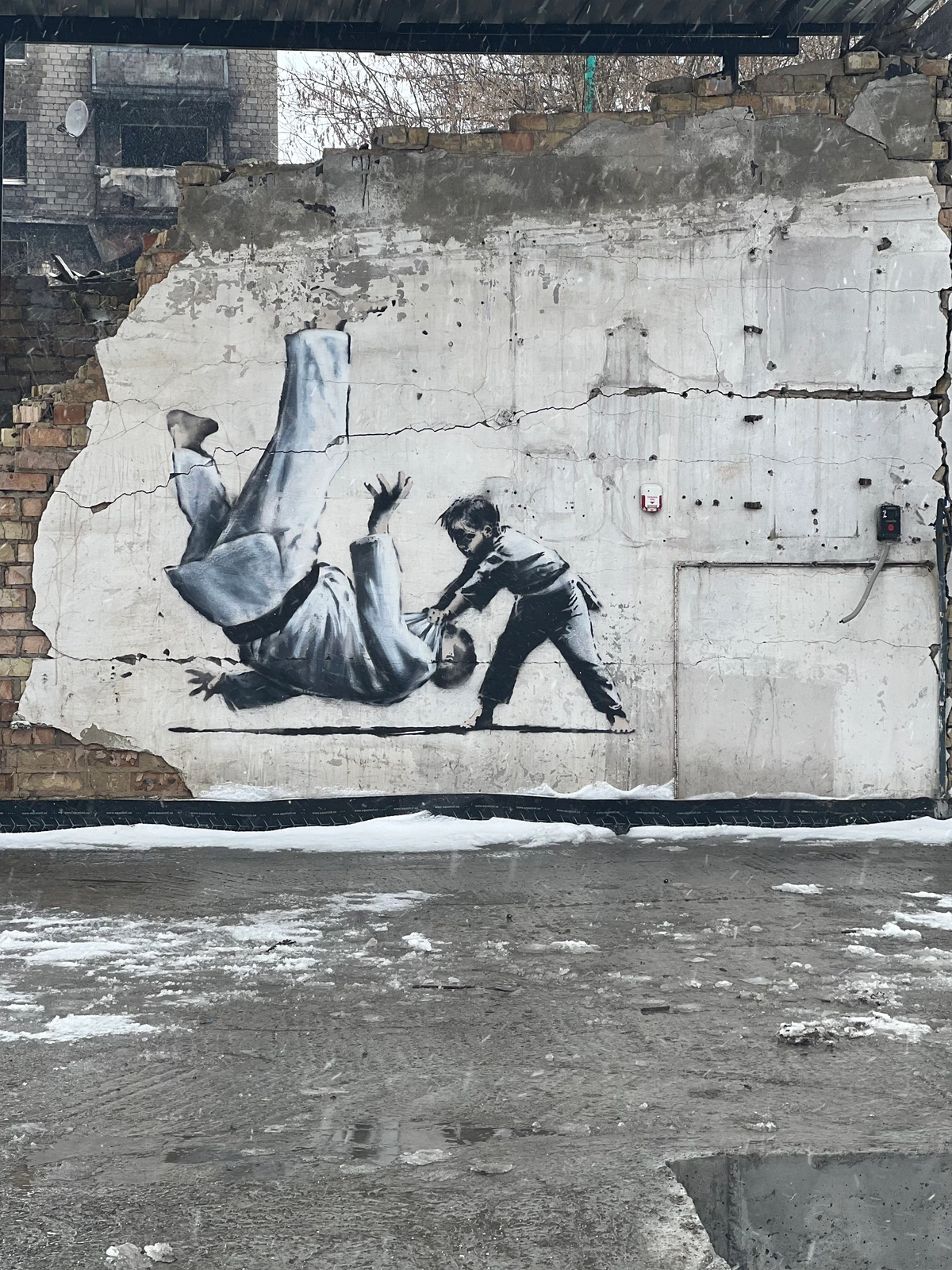 Banksy mural in Borodyanka, Ukraine, depicting a child performing a judo throw on a man.