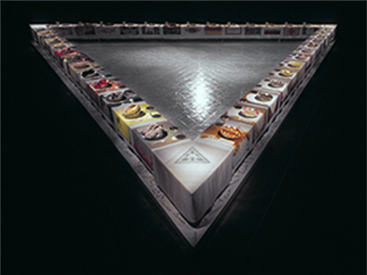 Judy Chicago's iconic feminist art installation, 'The Dinner Party', featuring a triangular table with elaborate place settings for influential women.