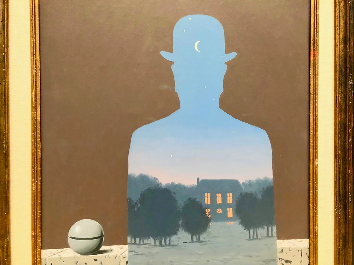 René Magritte's 'The Fifth Season' painting, showing a silhouette of a man in a bowler hat filled with a night landscape of a house and trees.