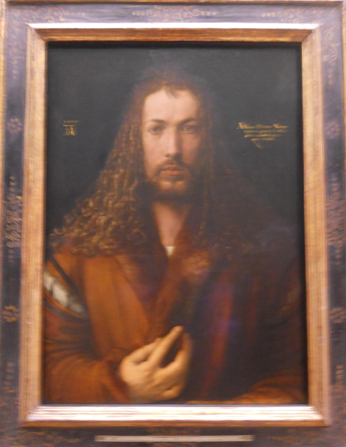 Self-Portrait by Albrecht Dürer, painted in 1500, showing the artist with long curly hair and a beard, wearing a fur-trimmed robe.