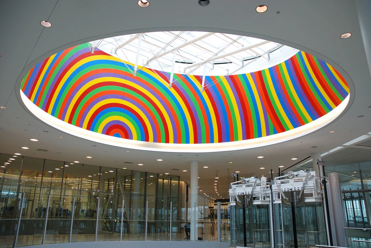 Sol LeWitt's Wall Drawing #1100: A vibrant modern artwork featuring concentric circular bands of rainbow colors on a museum ceiling, highlighting geometric precision and color theory in contemporary art.