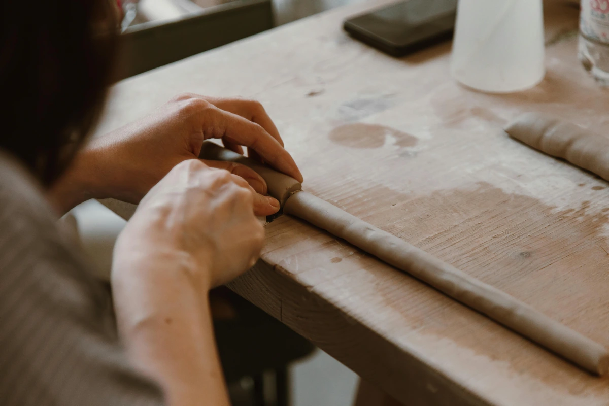 Close-up of woman sculpting clay, showcasing the meticulous art-making process