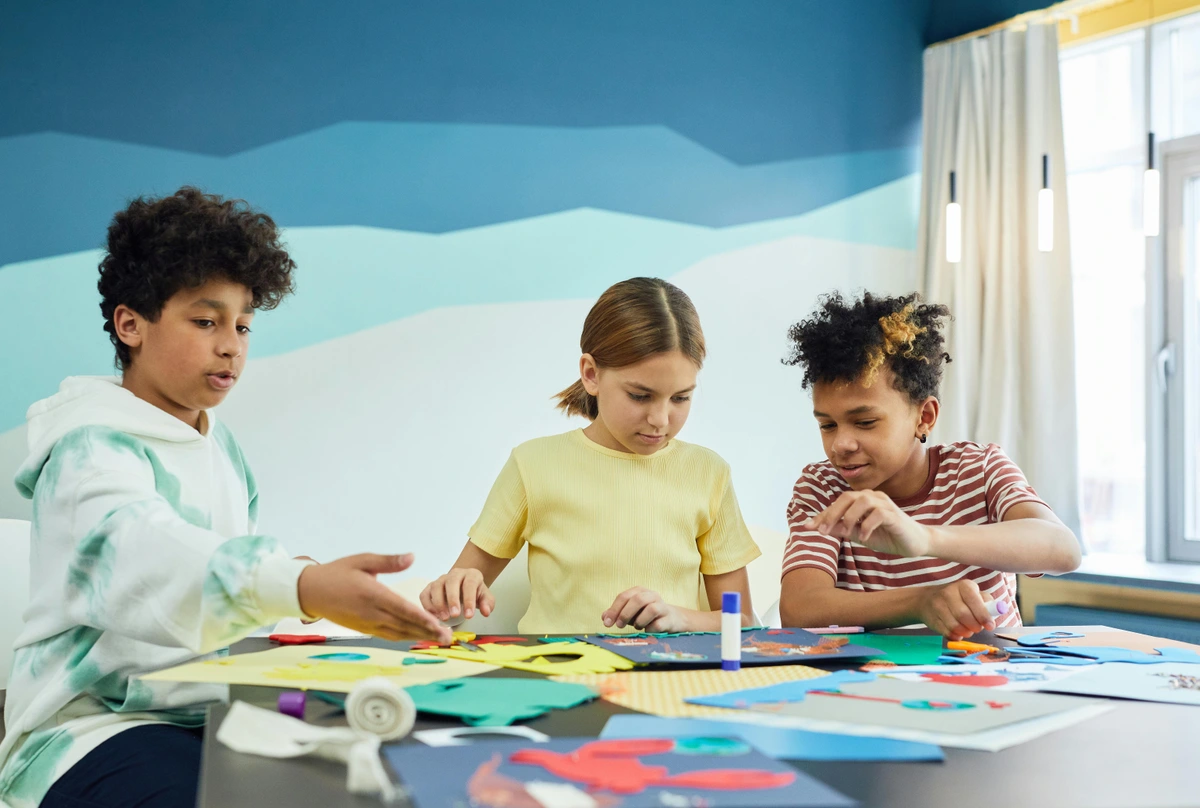 A group of children engaged in creative art projects, exploring the meaning and purpose of art-making.