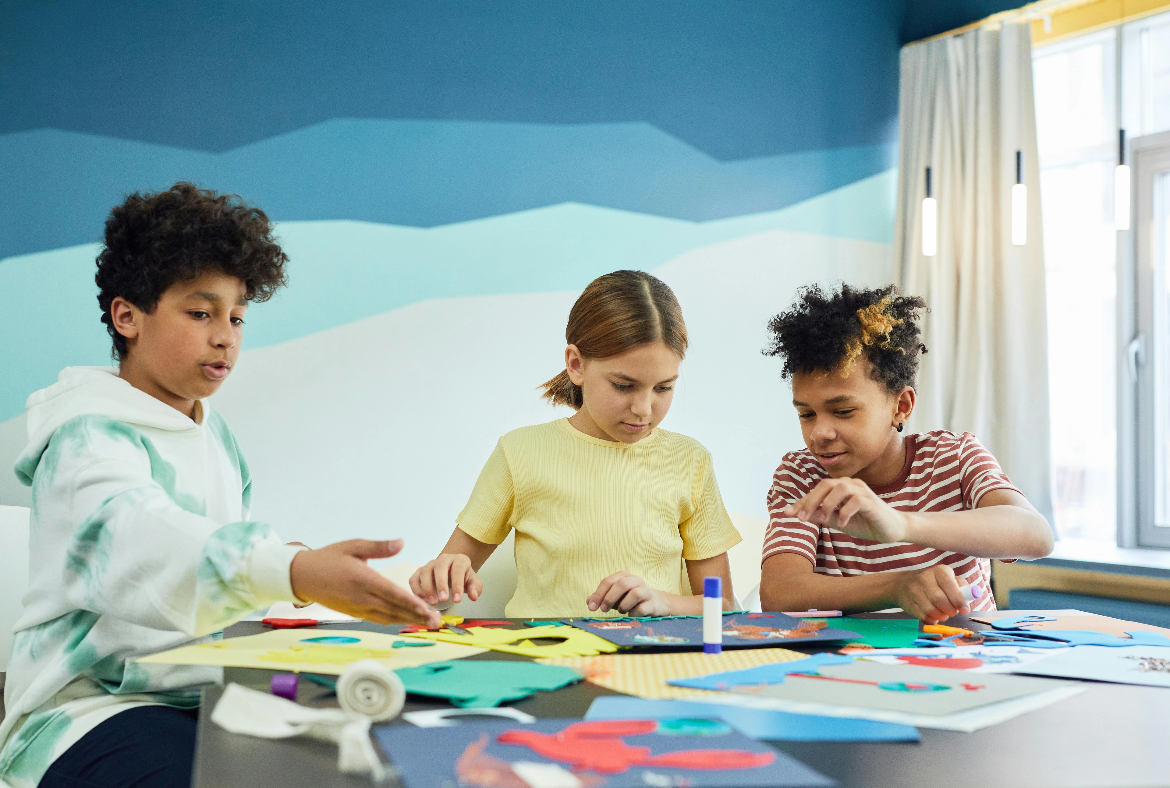 A group of children engaged in creative art projects, exploring the meaning and purpose of art-making.