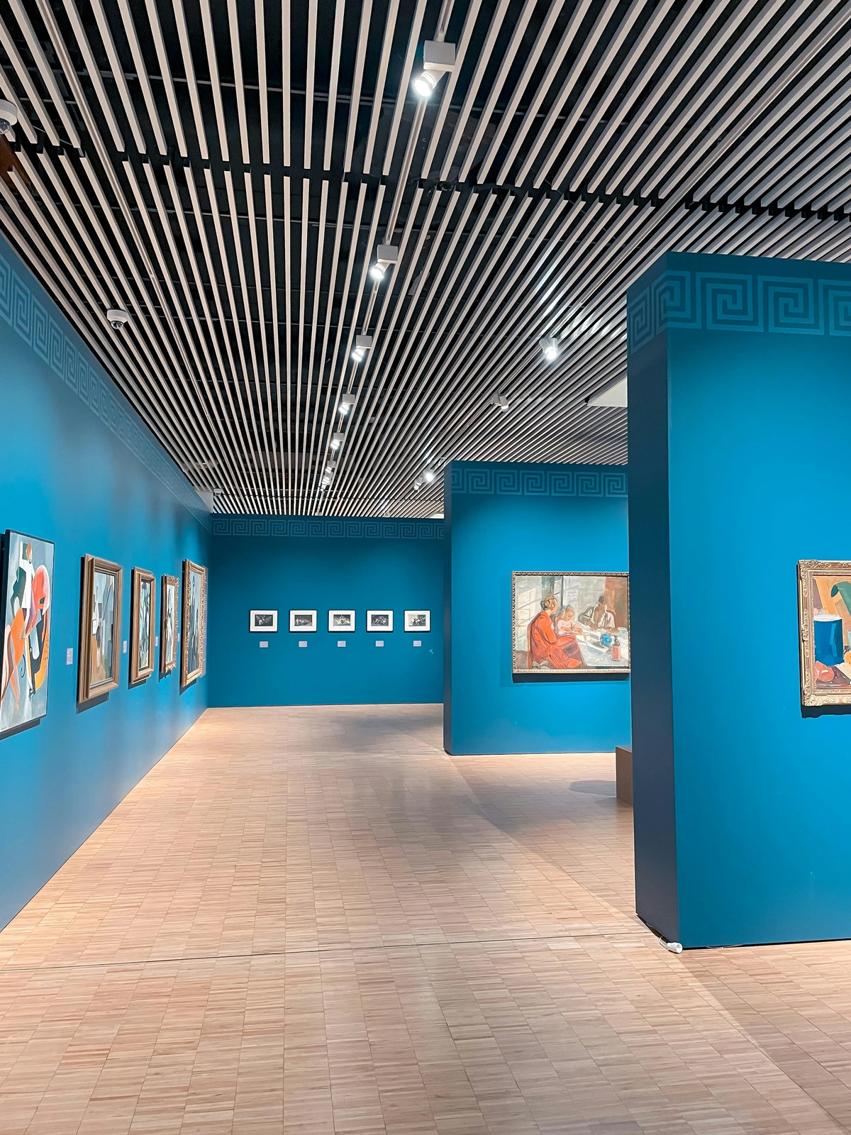 Art Gallery Interior with Modern and Traditional Artworks Displayed on Blue Walls for Art Collecting Enthusiasts - Free Stock Photo