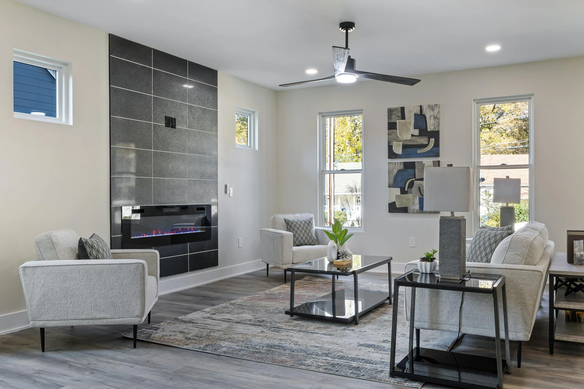 Cozy living room featuring a modern fireplace with abstract art above, comfortable seating, and a stylish rug.