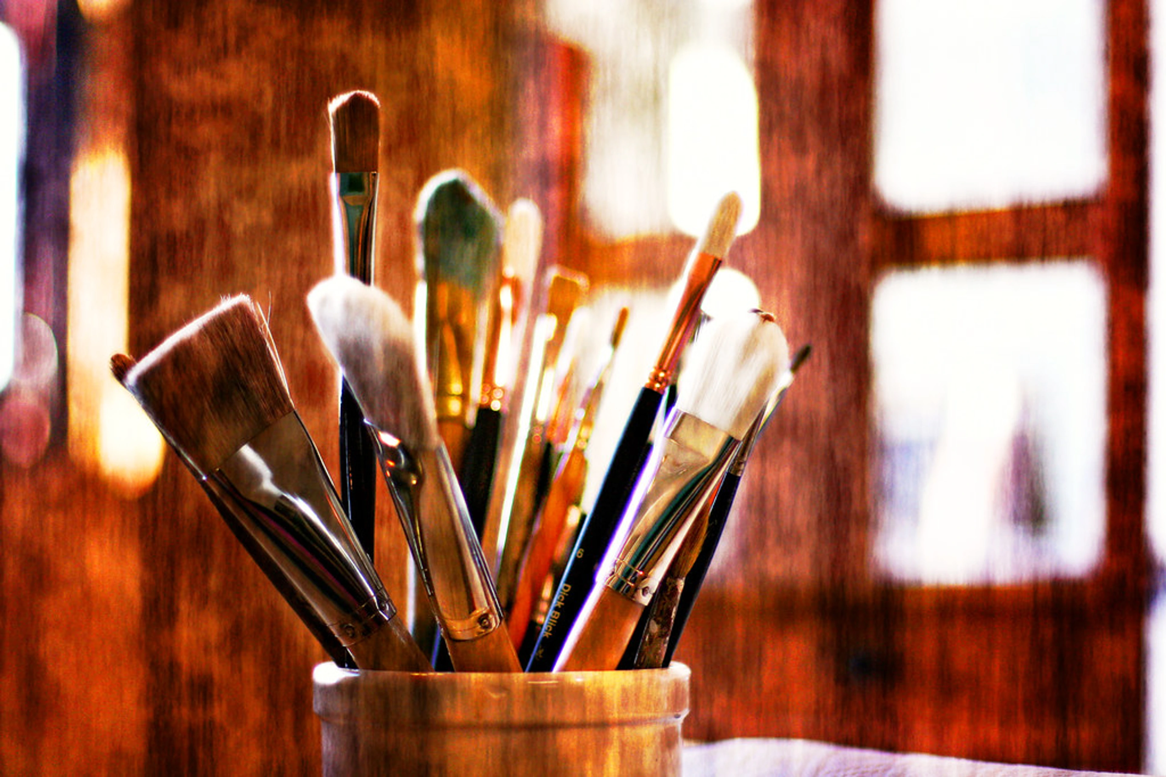 A close-up of various paint brushes, suggesting essential tools for an artist's studio.