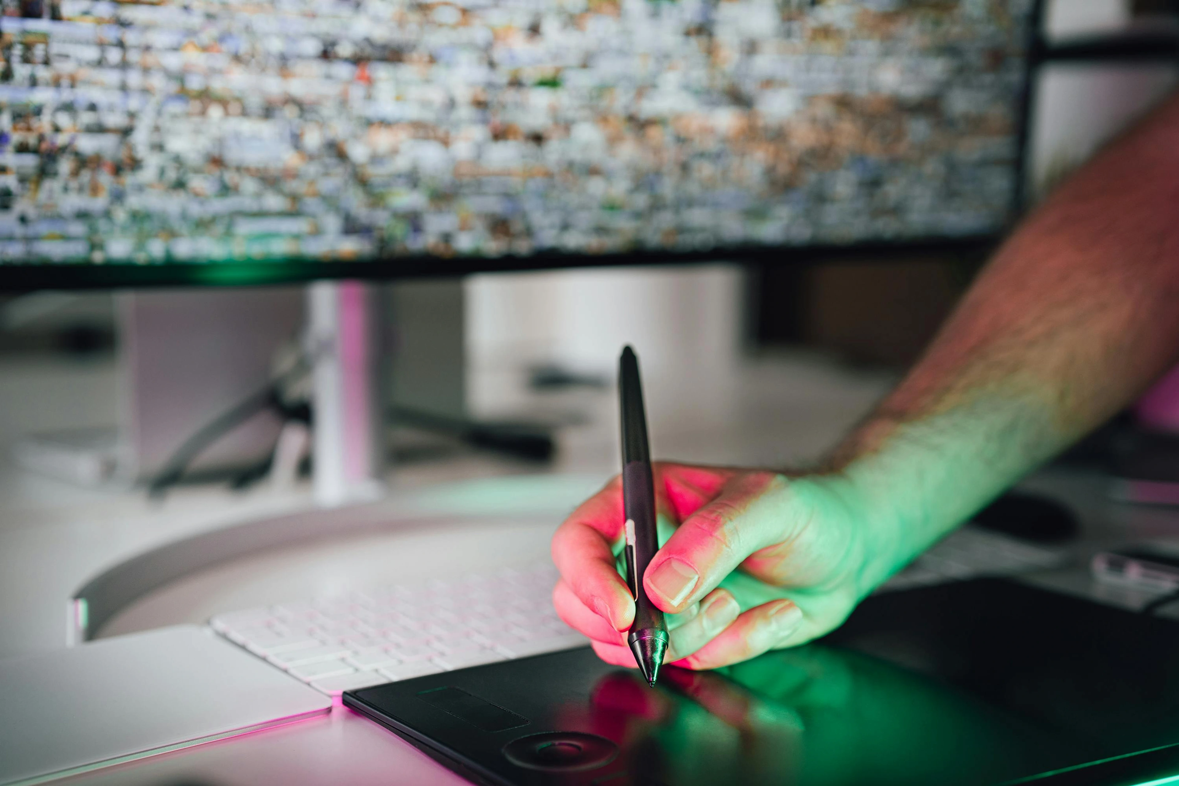 A person's hands holding a stylus and drawing on a digital tablet, with a blanket in the background.