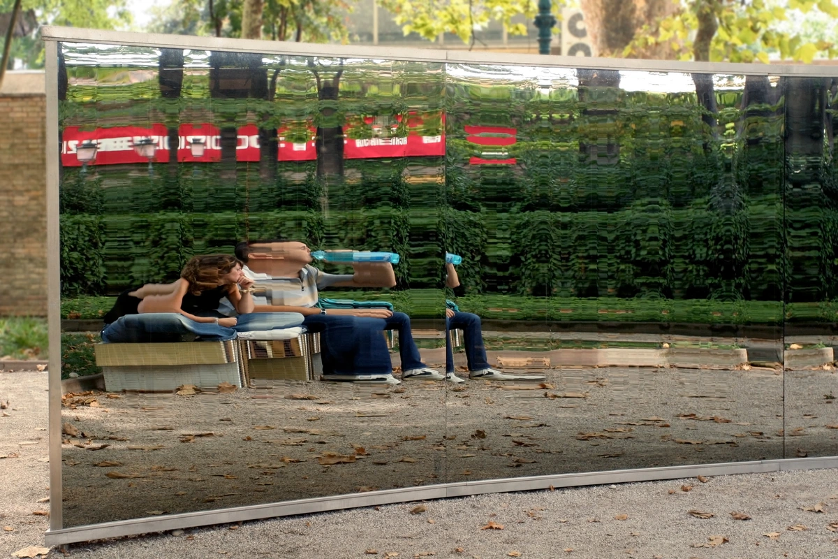 People sitting in front of a distorted mirror reflecting the Venice Biennale 2005 art installation.