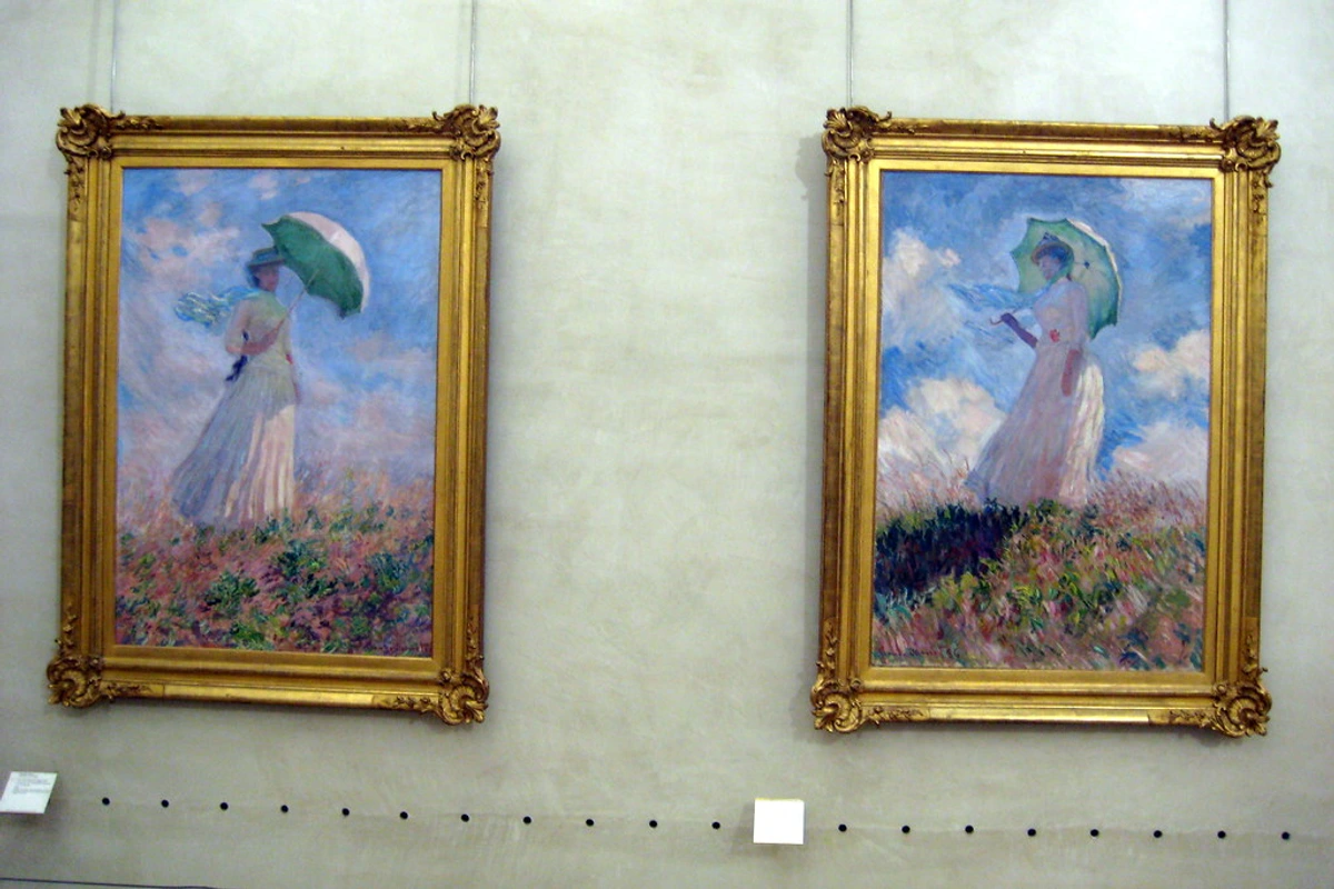 Two paintings by Claude Monet of women with umbrellas in a field, displayed in a museum.