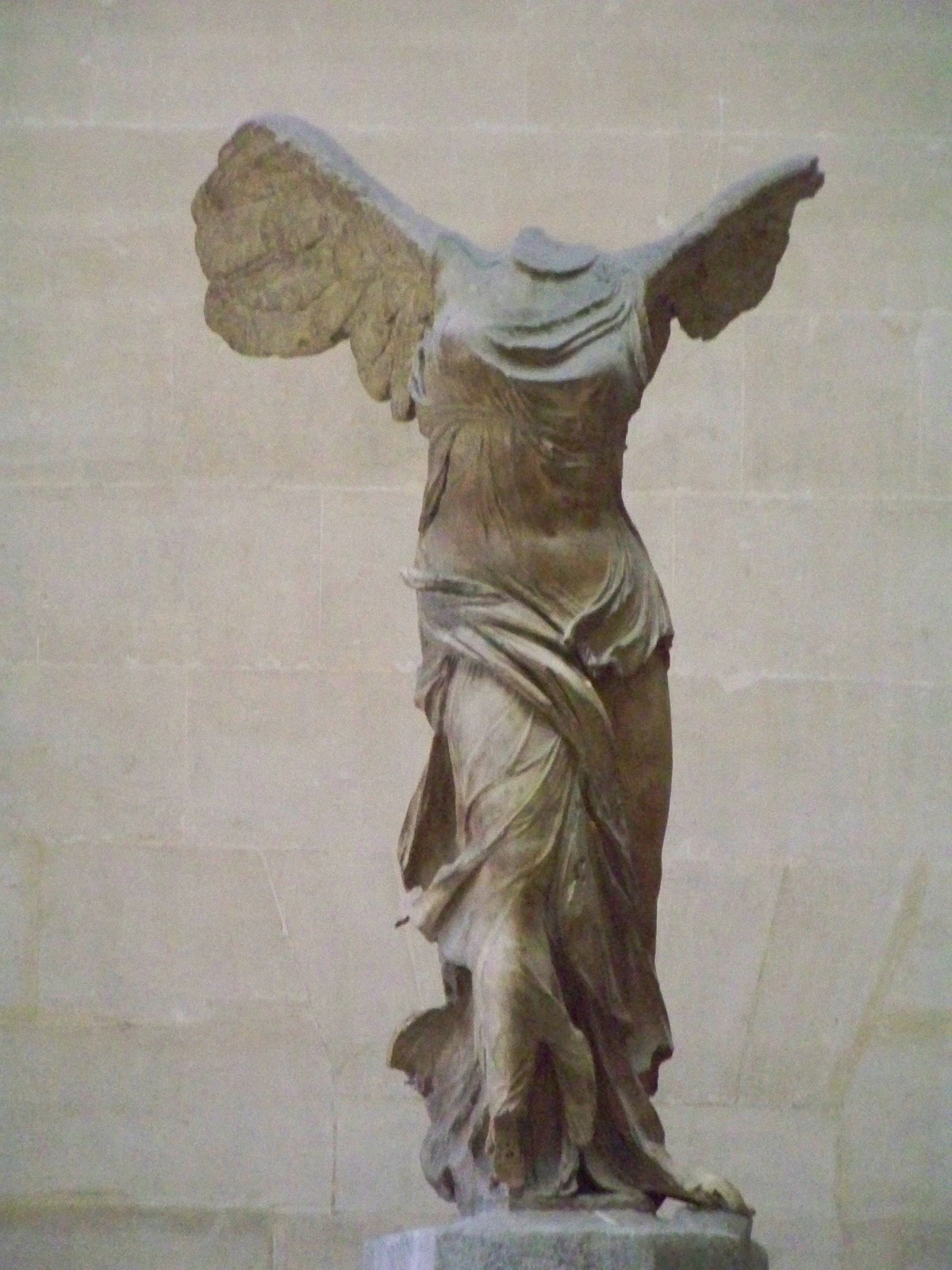 The Winged Victory of Samothrace, a headless marble statue of Nike, the Greek goddess of victory, displayed at the Louvre Museum.