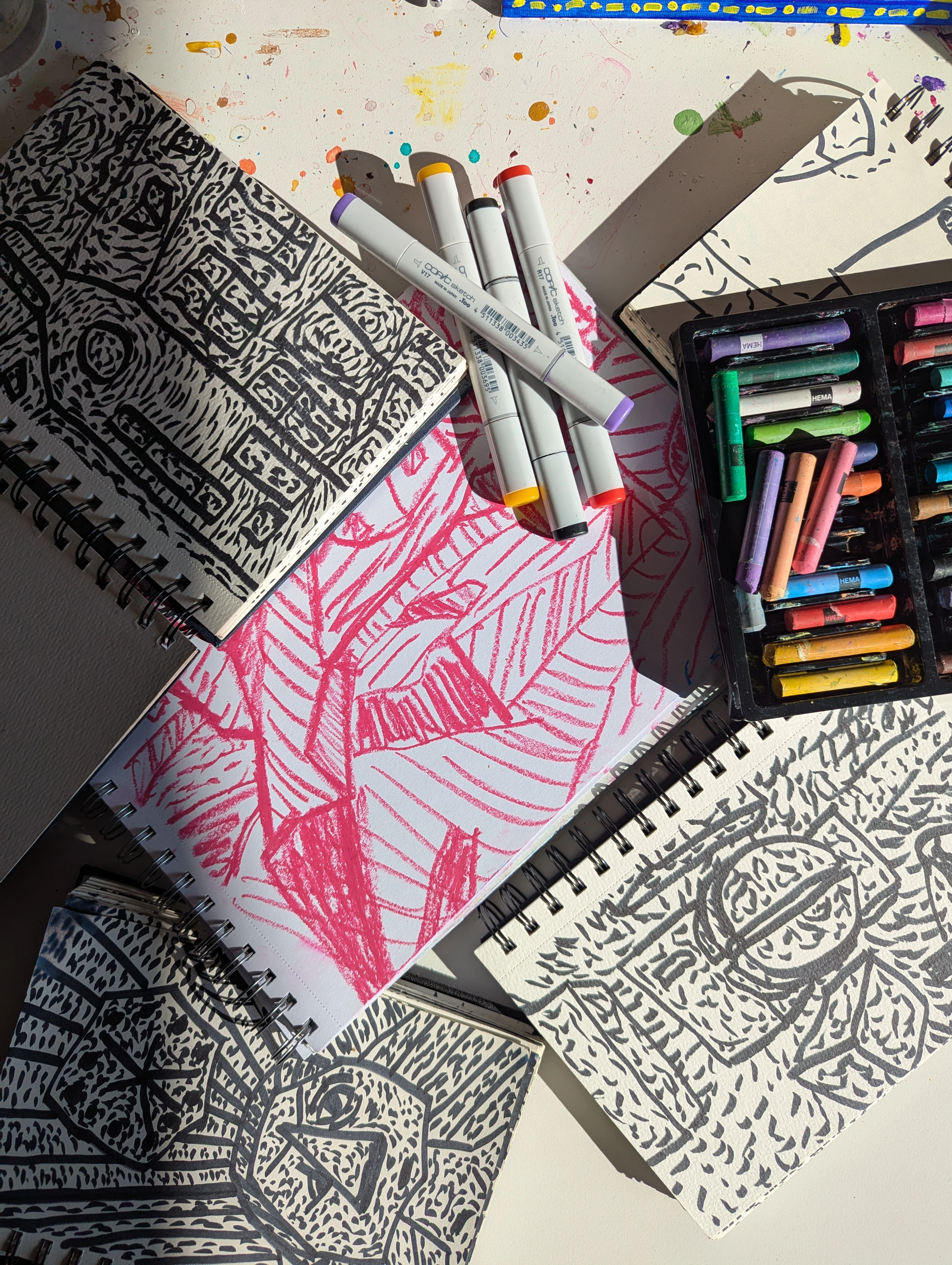 Table covered with child's art supplies: colorful markers, sketches, and paint spots, celebrating creative expression and the joy of creation.