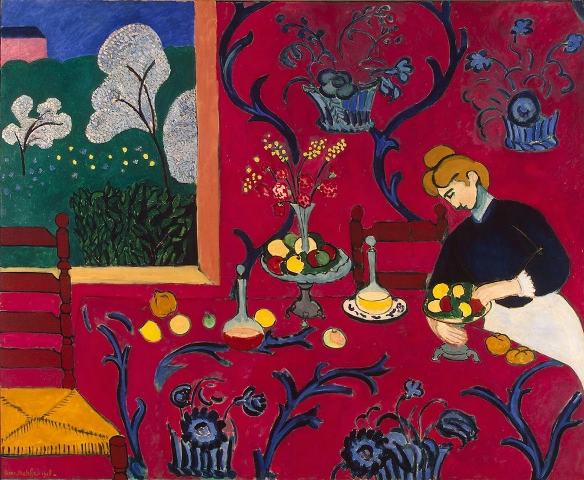 Henri Matisses 'De Rode Kamer' (Harmonie in rood), een levendig schilderij met een vrouw die fruit rangschikt op een rode tafel met blauwe bloemenpatronen, naast een raam met uitzicht op een groen landschap.