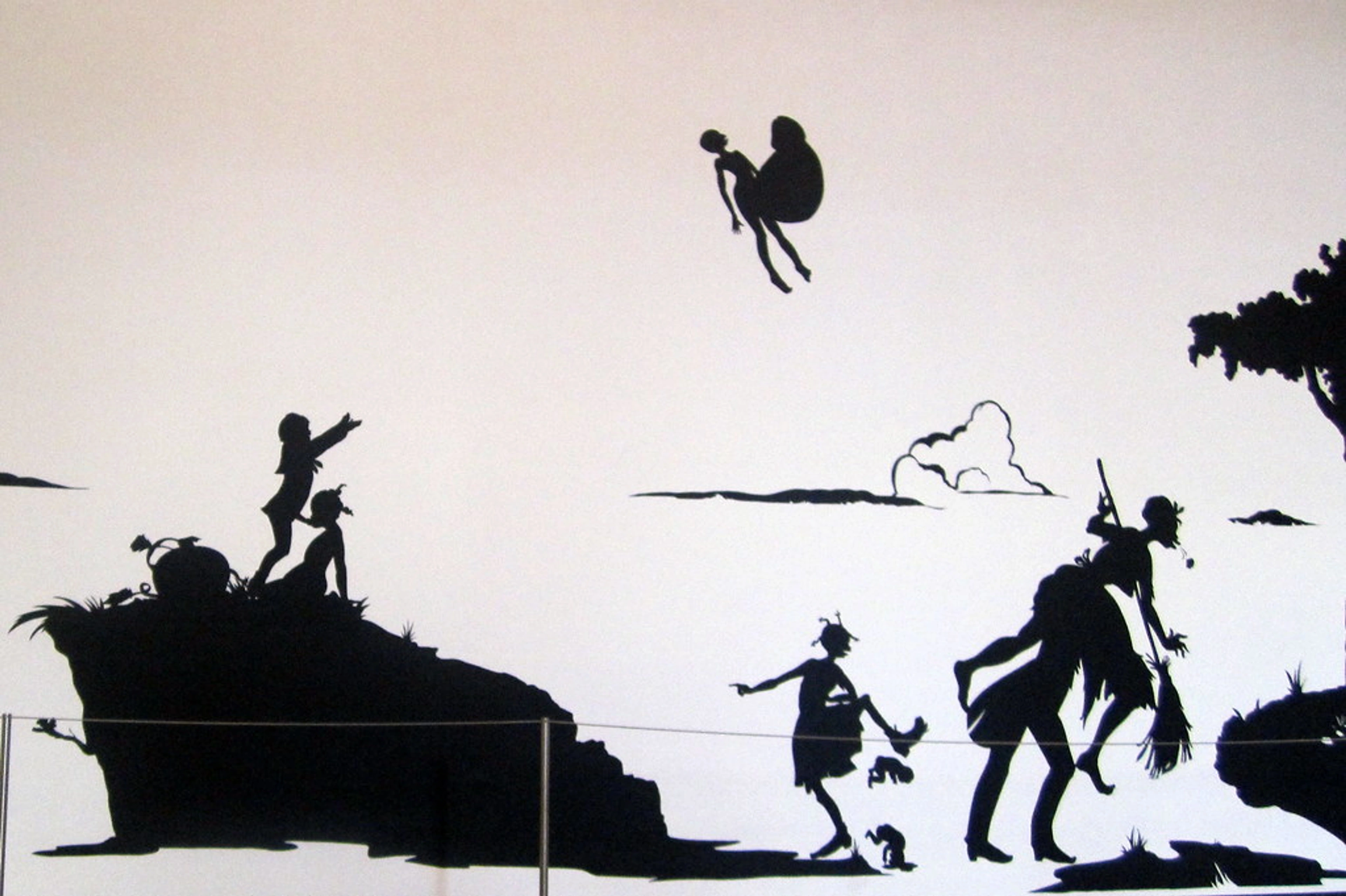 Black silhouette artwork from MoMA's 'Gone: An Historical Romance of a Civil War' exhibition, showing figures flying, on hills, and interacting in a stylized landscape.