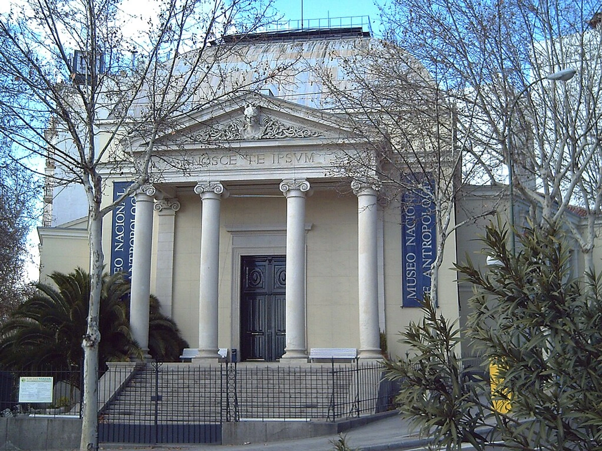 Exterior view of the Museo Nacional de Antropología in Madrid, Spain, showcasing its neoclassical facade with columns and signage.