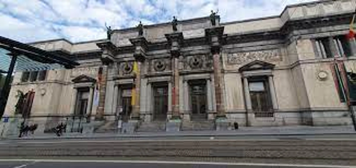 Exterior view of the Royal Museums of Fine Arts of Belgium in Brussels, a grand classical building with statues and tram tracks in the foreground.