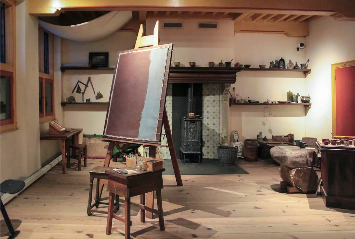Rembrandt's recreated 17th-century artist studio at the Rembrandt House Museum, featuring an easel, fireplace, and historical art tools.