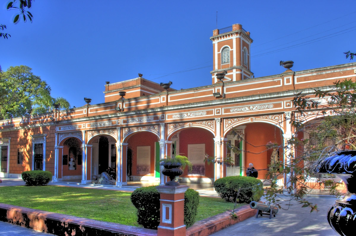 Palacio Cantón, Mérida, Yucatán. Historic orange museum building with arches, tower, and courtyard under blue sky.