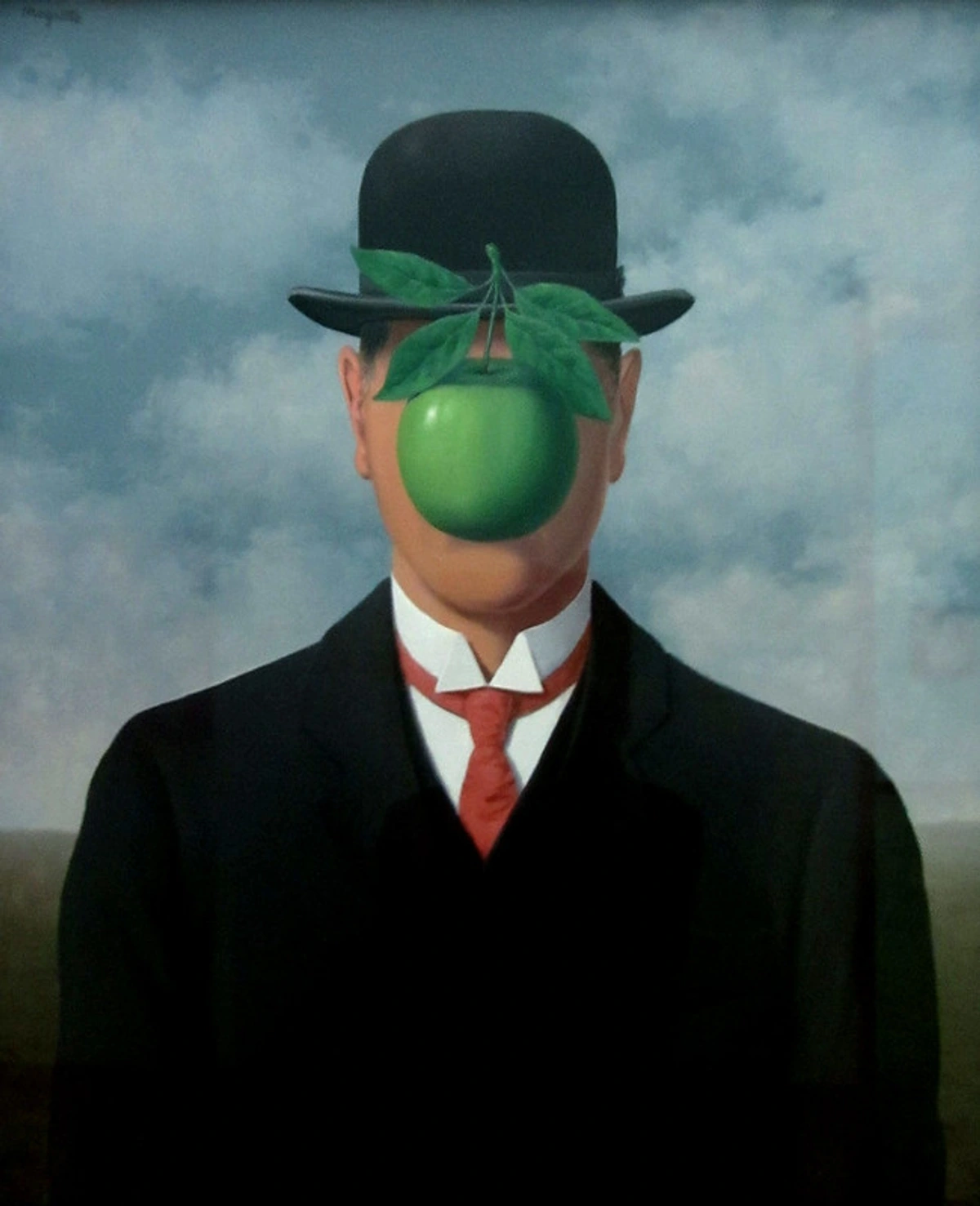 Surrealist painting by René Magritte depicting a man in a bowler hat whose face is obscured by a floating green apple. He wears a dark suit and a red tie against a backdrop of the sea and cloudy sky.