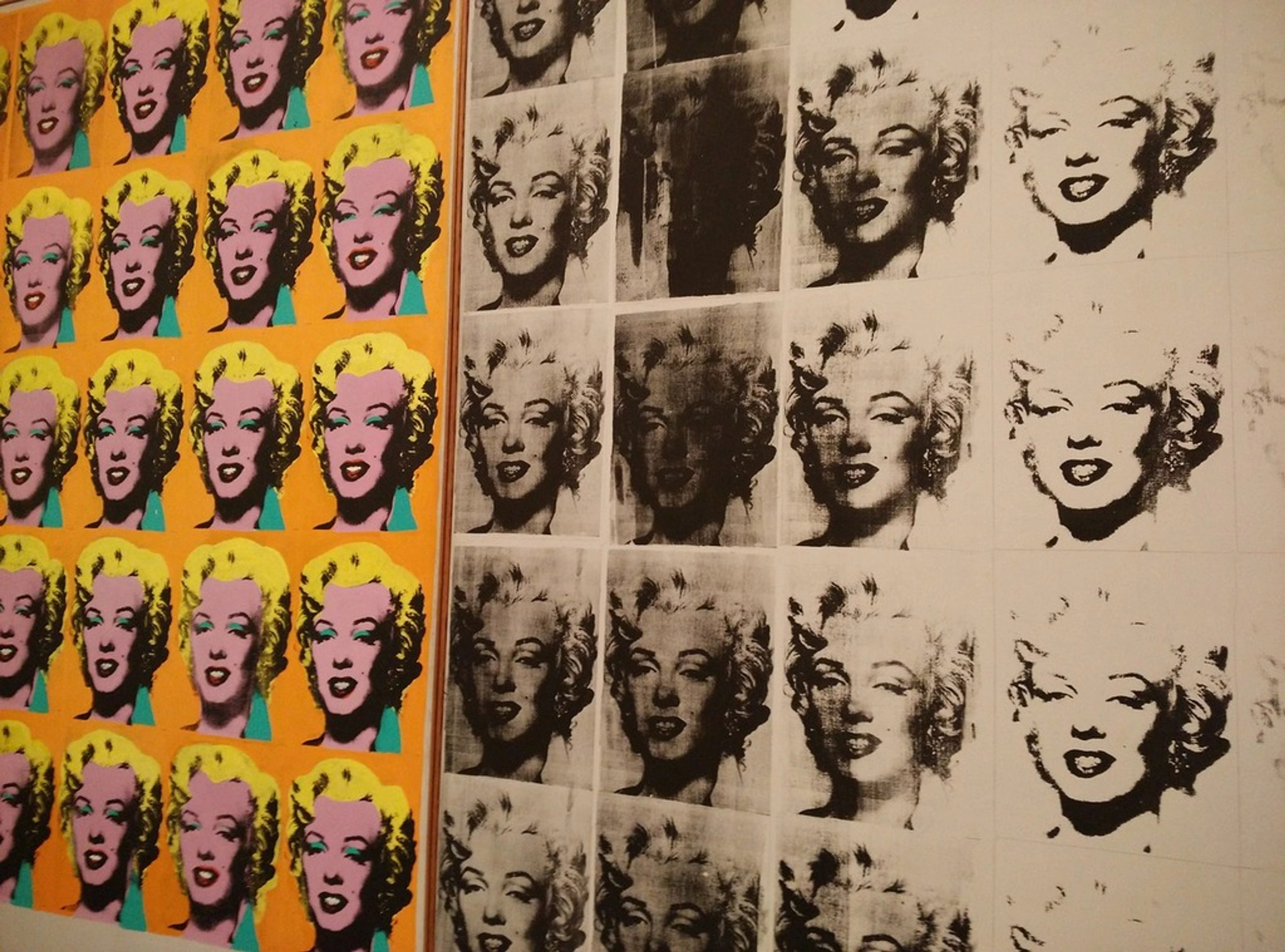 Close-up view of Andy Warhol's "Marilyn Diptych," featuring multiple screen-printed images of Marilyn Monroe in vibrant colors on the left and grayscale on the right.