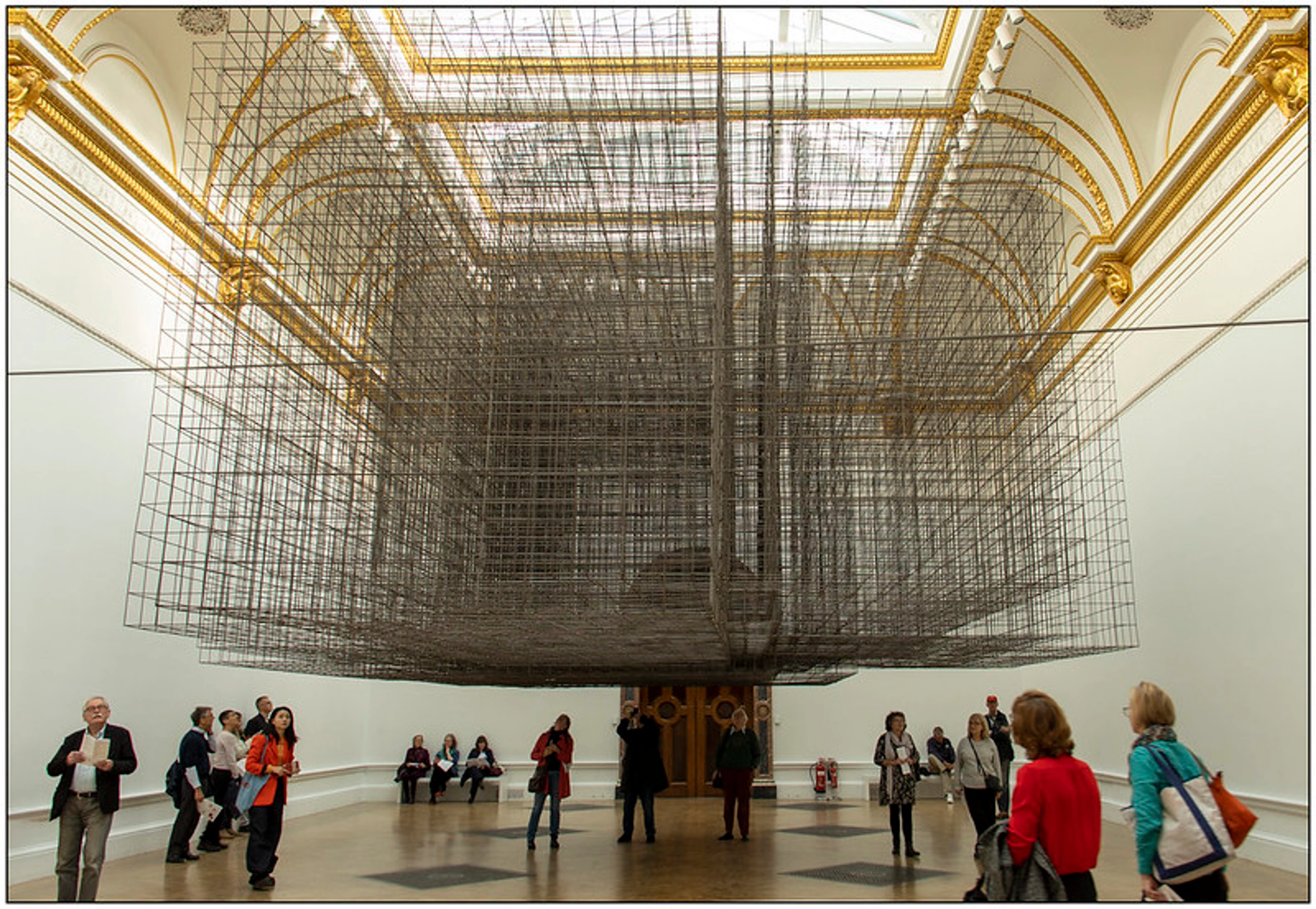 Minimalist wire sculpture by Antony Gormley, 'Matrix I,' suspended in a gallery, exemplifying simplicity in form.